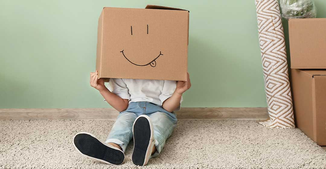 child with box on his head with drawn on smiley face, child custody and relocation in florida