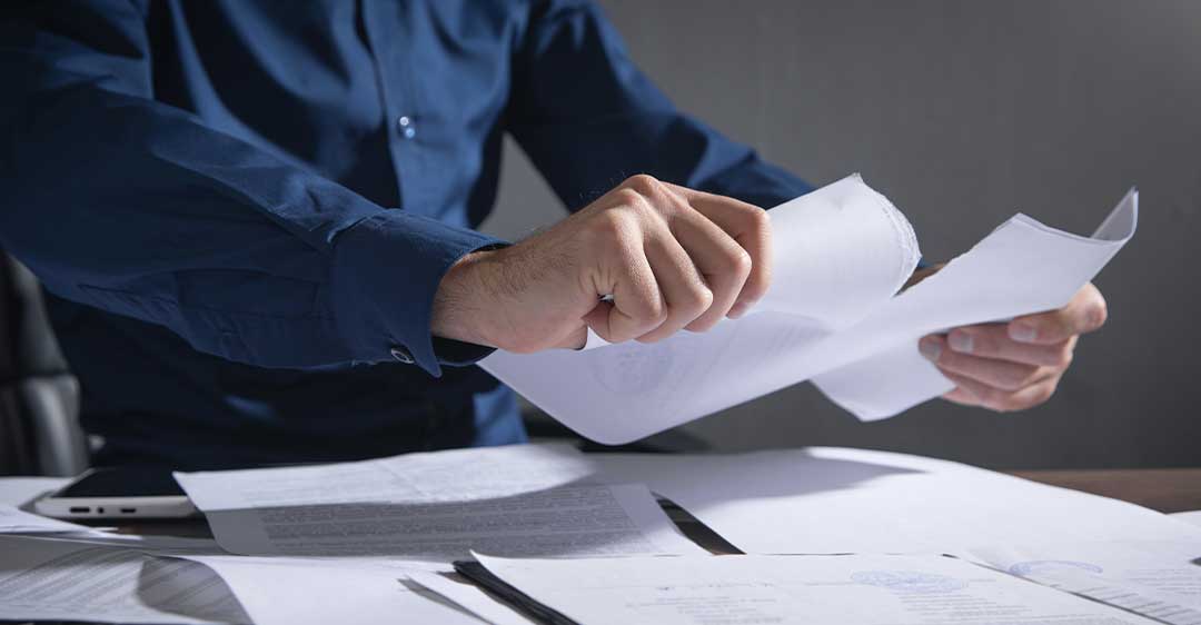 businessman tearing contract at desk, the most common defenses to breach of contract