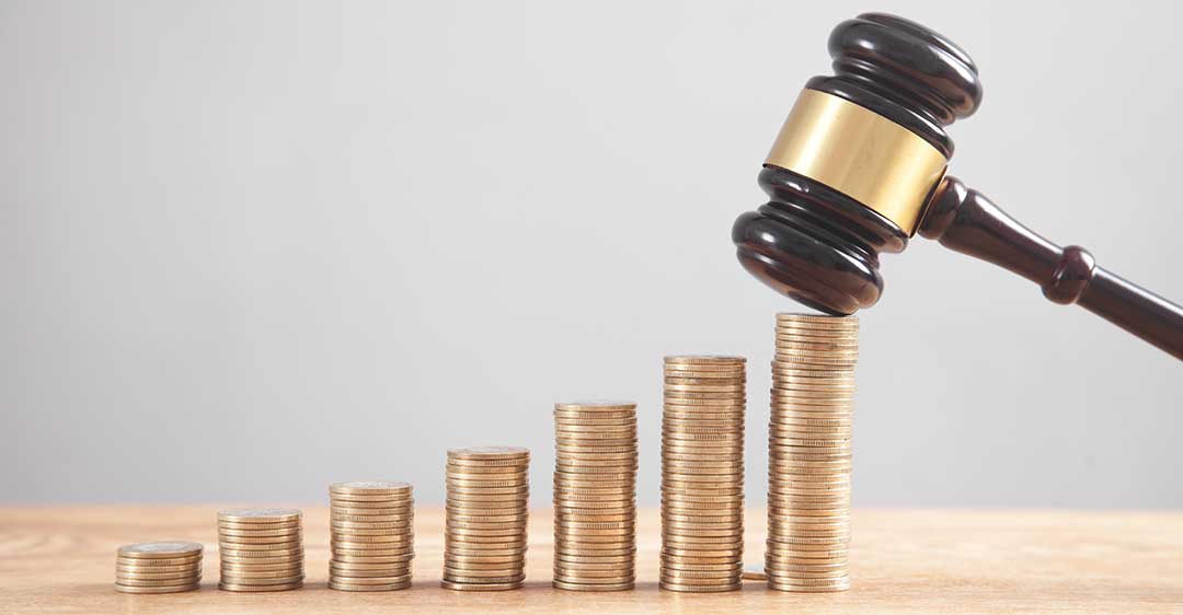 Stack of coins with gavel, legal fees for businesses