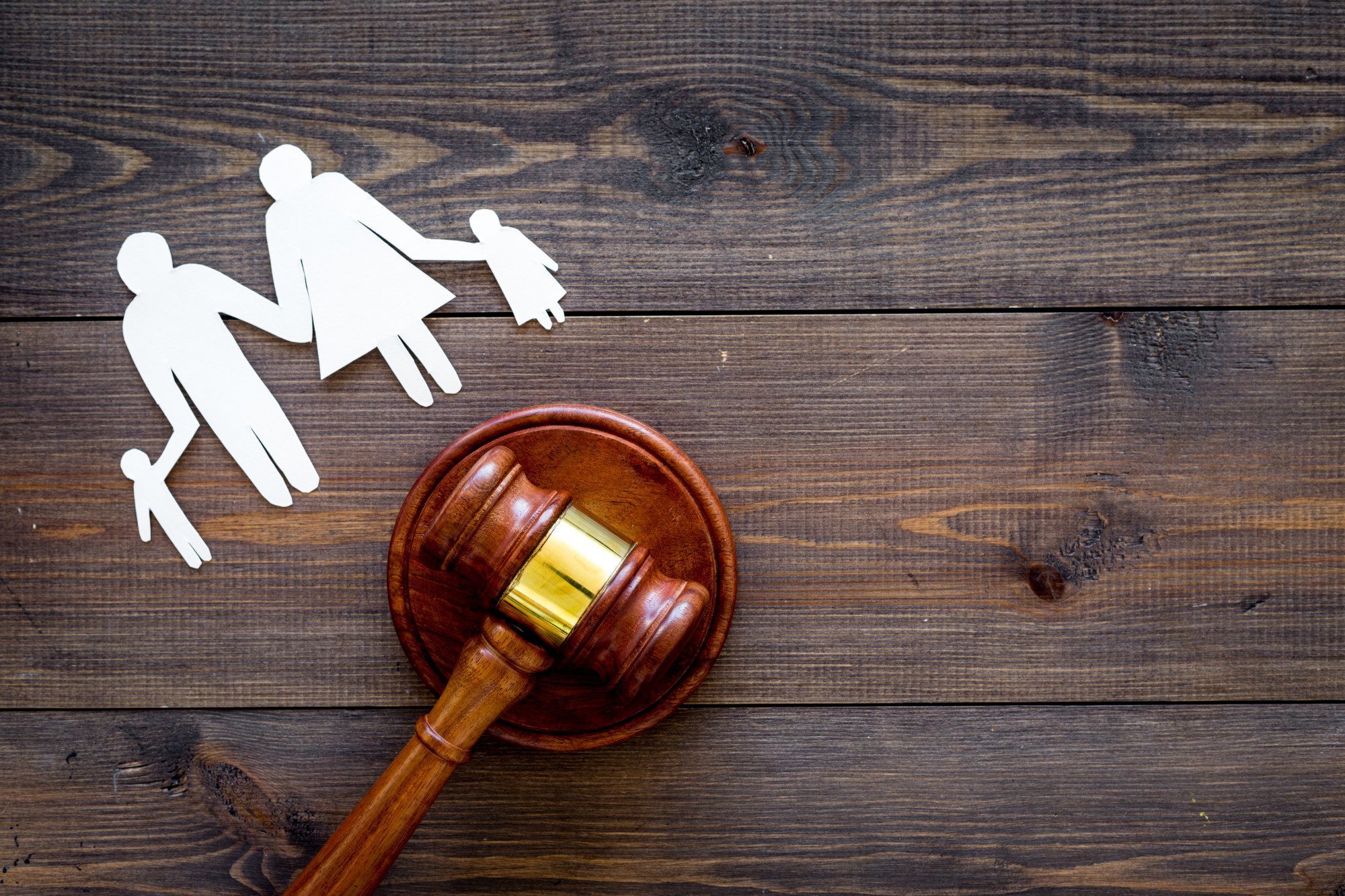 Family with children cutout near court gavel on dark wooden background, family law in jacksonville