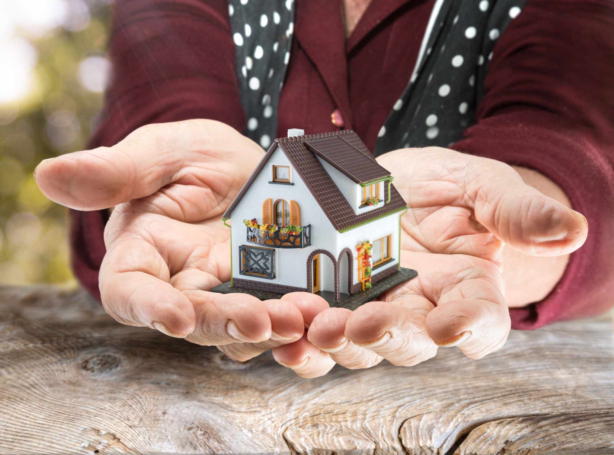 closeup of person’s hands holding model house, inheritance law