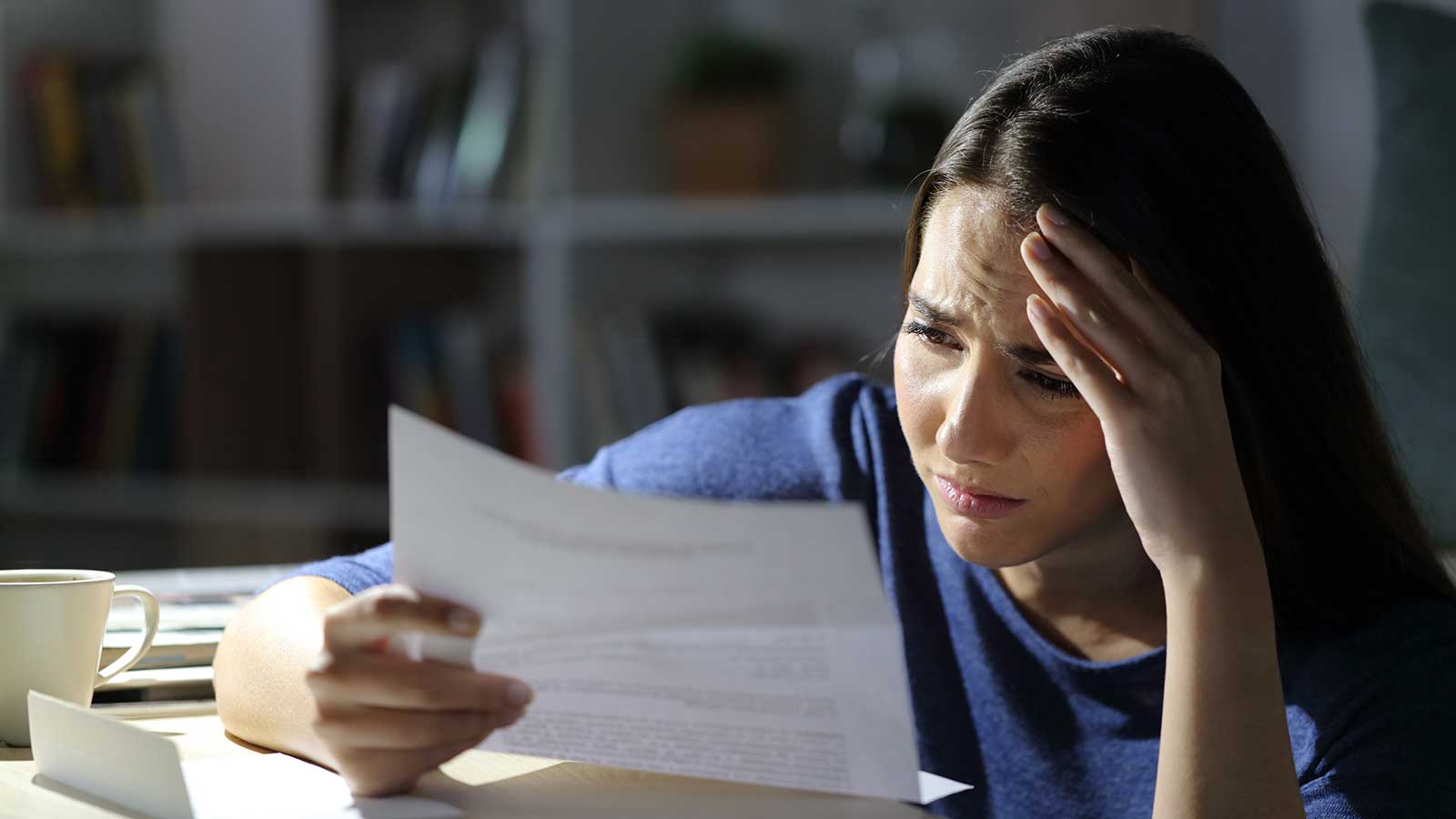 Worried woman reading bad news on letter, l1 visa denial reasons