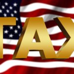 The word TAX in large, bold, gold letters is displayed in front of a waving American flag, symbolizing expertise from a civil litigation attorney Florida professionals rely on.