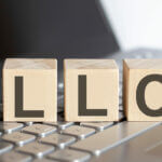 wood blocks with the letters L L C lon a laptop keyboard, llc formation