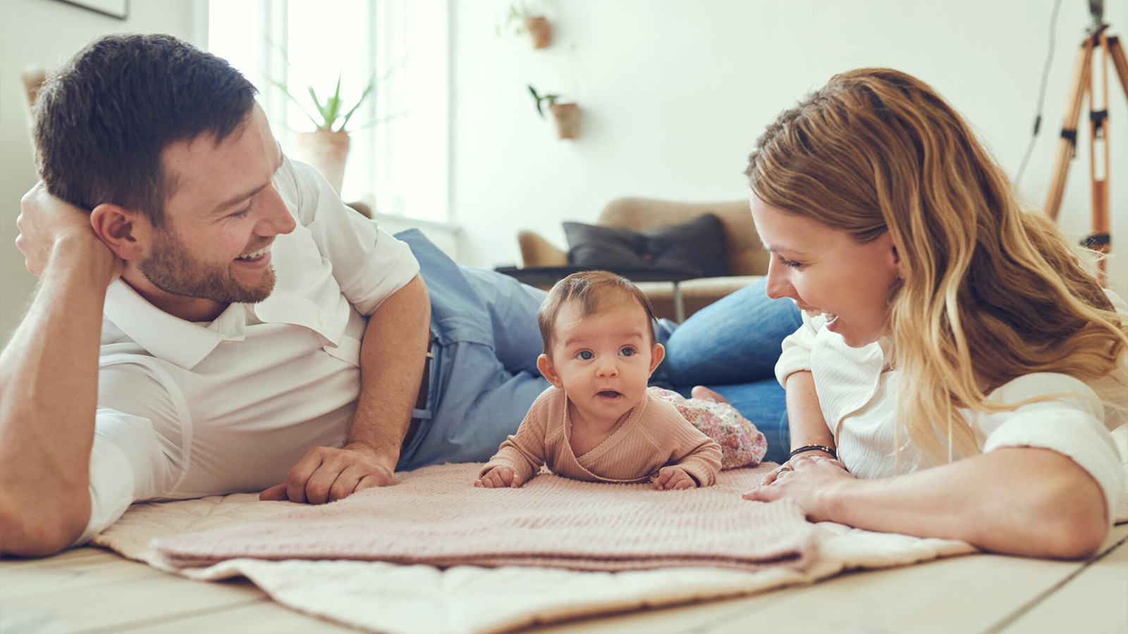 mother and father playing on blanket with infant, immigrant parents, citizenship