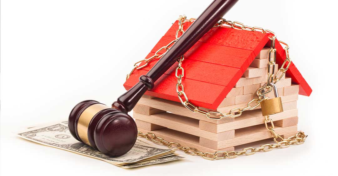 miniature block house with chains and padlock, gavel and cash, how to stop an illegal lien