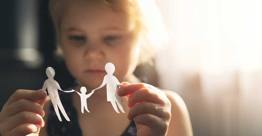 child holding paper cut out of family, international child custody, international family law, international parental child abduction, international parental child kidnapping