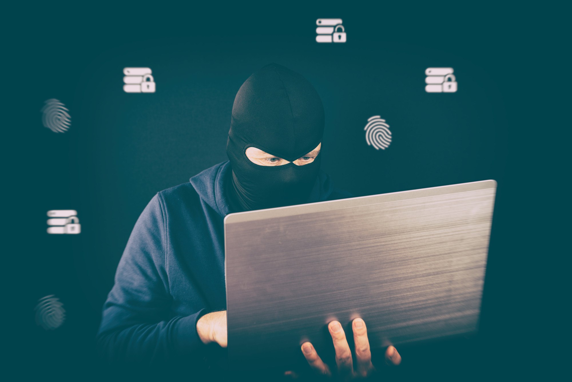masked man on laptop, email fraud, protect your business form email fraud as employees work from home